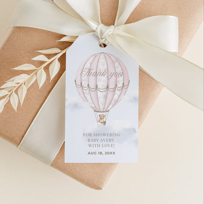 Gift box wrapped in brown paper with a white ribbon and 'Thank you' tag on a beige background