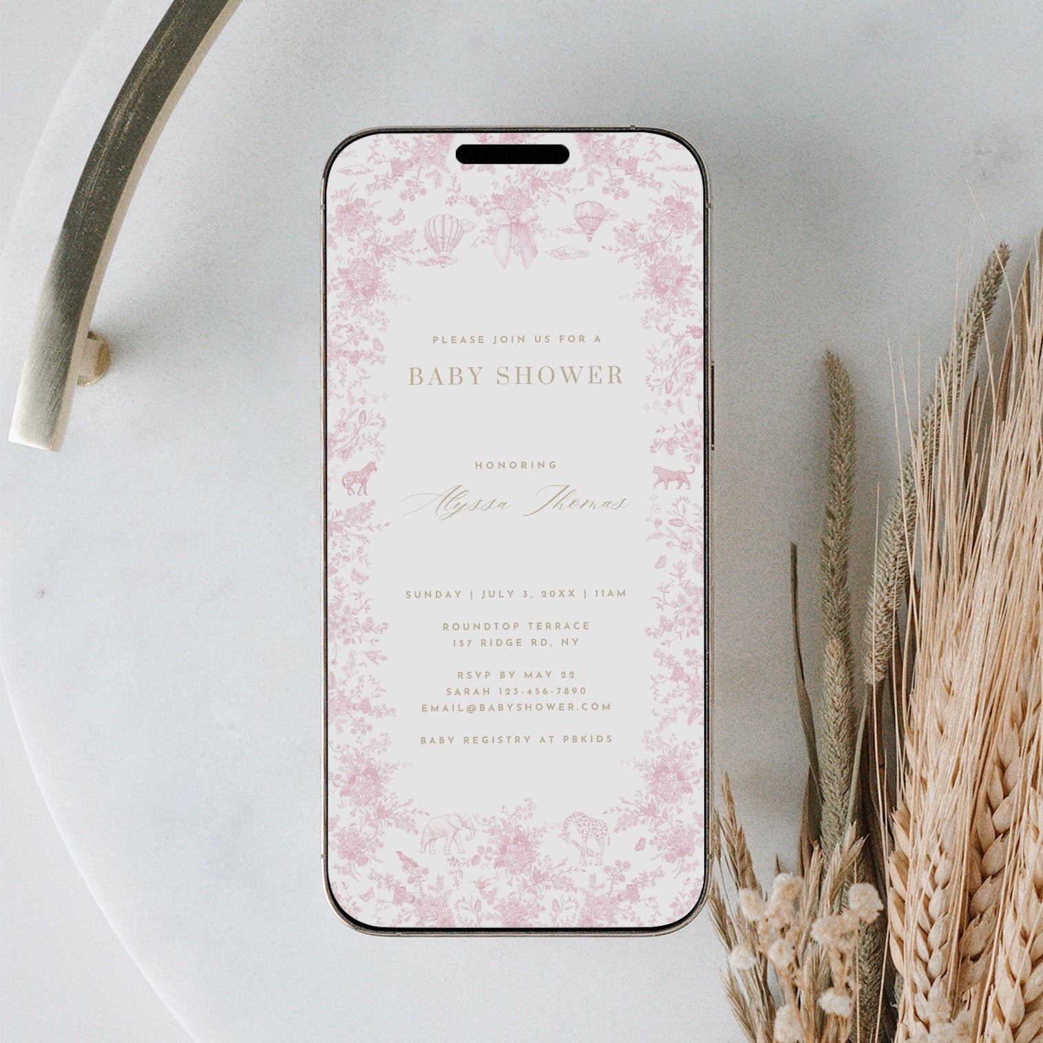 Phone with floral design case on a marble surface with dried plants