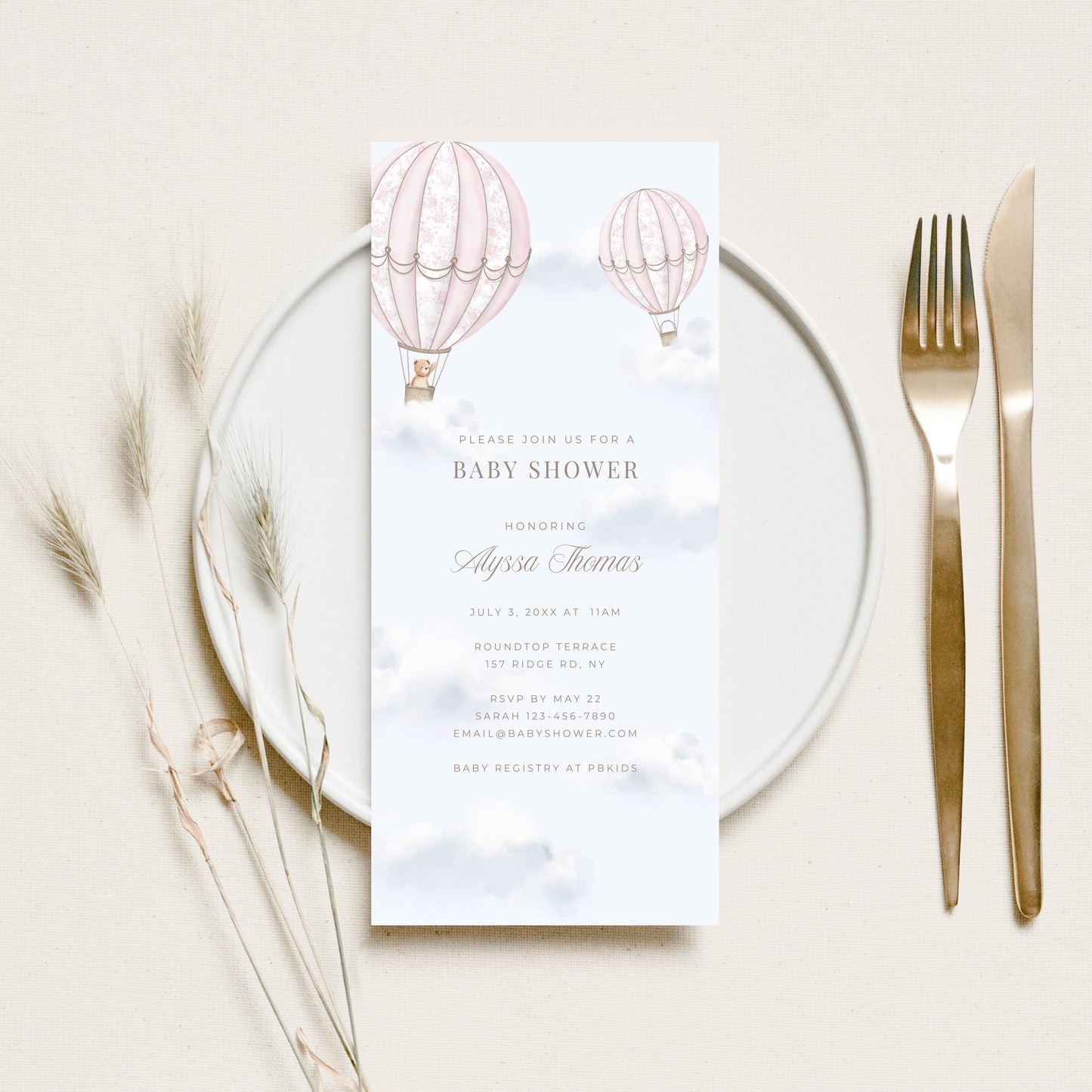 Baby shower menu card with hot air balloons on a white plate with cutlery