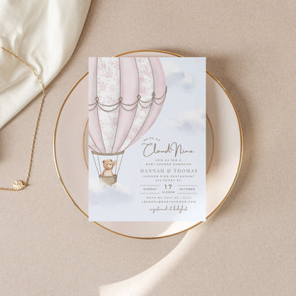 Baby Shower invitation card with hot air balloon design on a beige surface