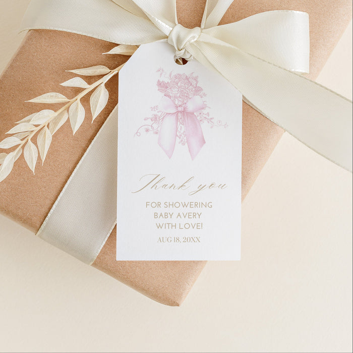 Gift box wrapped in brown paper with a white ribbon and decorative tag on a beige background