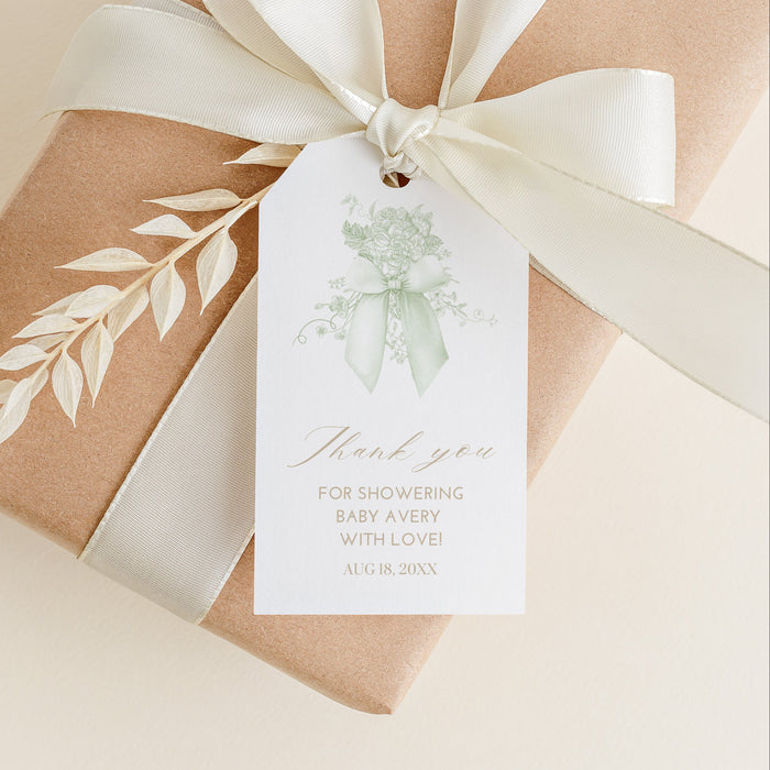 Gift box wrapped in brown paper with a white ribbon and decorative tag on a beige background