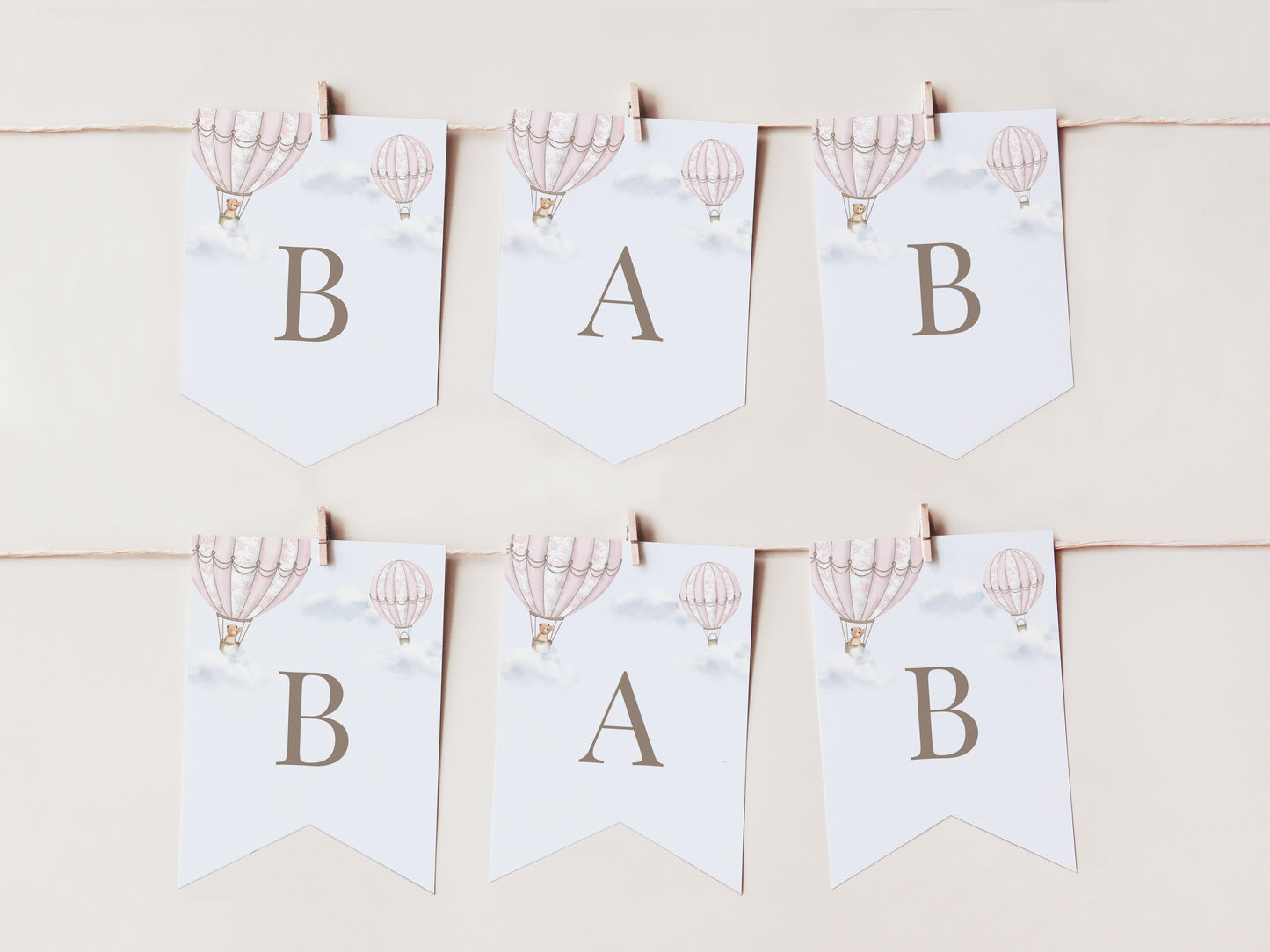 Baby shower banner with hot air balloons and letters 'B', 'A', 'B' on a light background